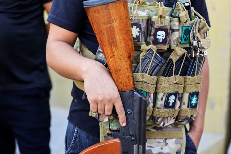 A member of Sadr's Peace Brigades fighters holds a weapon during clashes with the Iraqi security forces near the Green Zone, in Baghdad, Iraq August 30, 2022. REUTERS/Thaier Al-Sudani