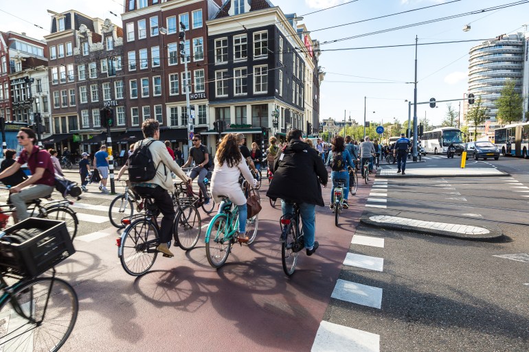 AMSTERDAM, THE NETHERLANDS - JUNE 16, 2016: People riding bicycles in historical part of Amsterdam in a beautiful summer day, The Netherlands on June 16, 2016