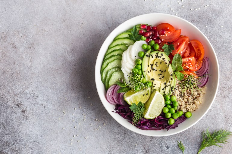 healthy vegan lunch bowl. Avocado, quinoa, tomato, cucumber, red cabbage, green peas and radish vegetables salad. Top view; Shutterstock ID 604314275; purchase_order: AJ; job: ; client: ; other: