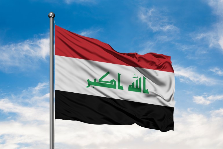 Flag of Iraq waving in the wind against white cloudy blue sky. Iraqi flag.