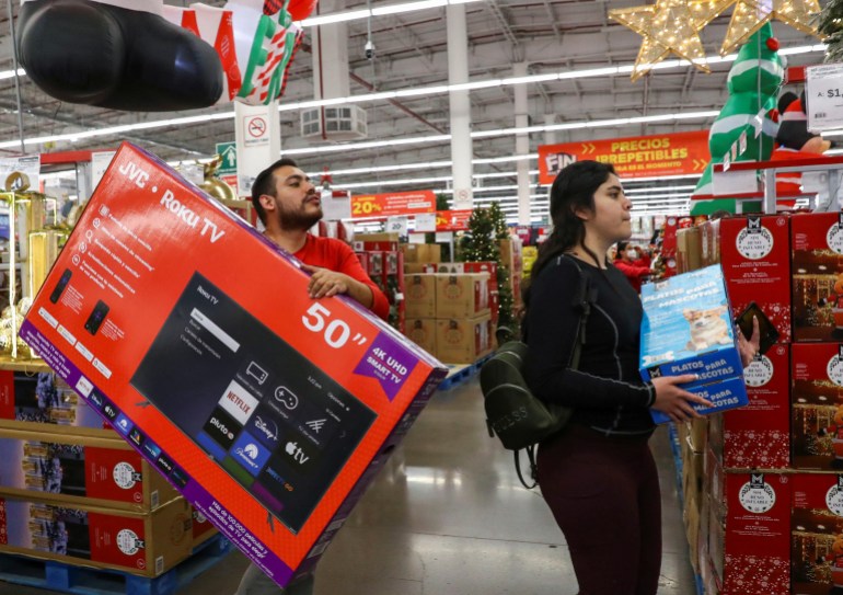 Customers carry a television screen and other items at Sam's Club store during the opening of Mexican shopping season event "El Buen Fin" (The Good Weekend) as consumers shop, emulating the "Black Friday" shopping, in Mexico City, Mexico, November 7, 2024. REUTERS/Henry Romero