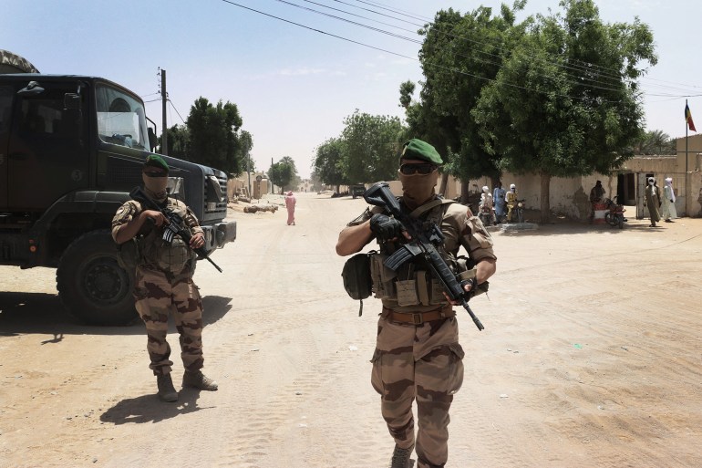 French soldiers from the Barkhane force patrol not far from the central square of Faya-Largeau, in northern Chad, on June 2, 2022. The Barkhane detachment in Faya-Largeau in Chad is one of the oldest detachments of the French anti-terrorist force. They carry out support missions for the benefit of the Chadian national army and develops civil-military projects. (Photo by AURELIE BAZZARA-KIBANGULA / AFP)