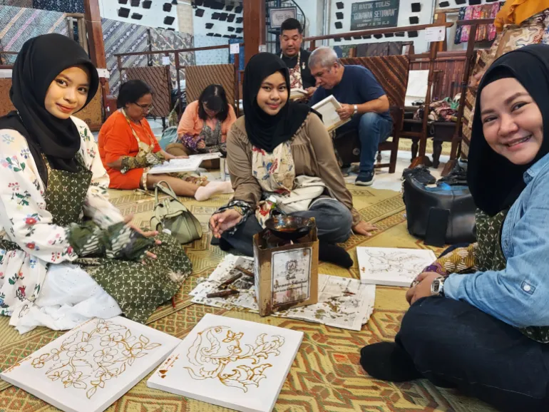 Young women get a hands-on lesson in batik in Solo [Aisyah Llewellyn/Al Jazeera]