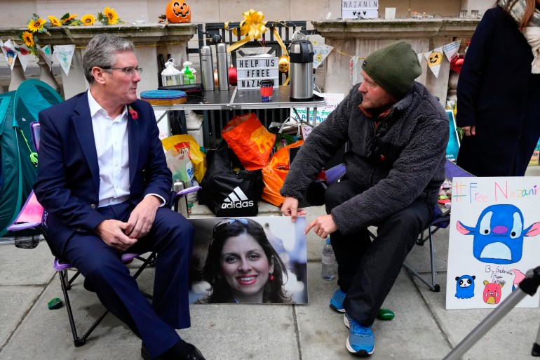 Richard Ratcliffe, the husband of detained charity worker Nazanin Zaghari-Ratcliffe, talks to British Labour leader Keir Starmer, left, as he continues with his hunger strike outside the Foreign, Commonwealth and Development Office in London, Tuesday Nov. 9, 2021. Ratcliffe began his hunger strike after a court decided his wife has to spend another year in an Iranian prison, she has already been detained for more than five years in Iran. (AP Photo/Frank Augstein)