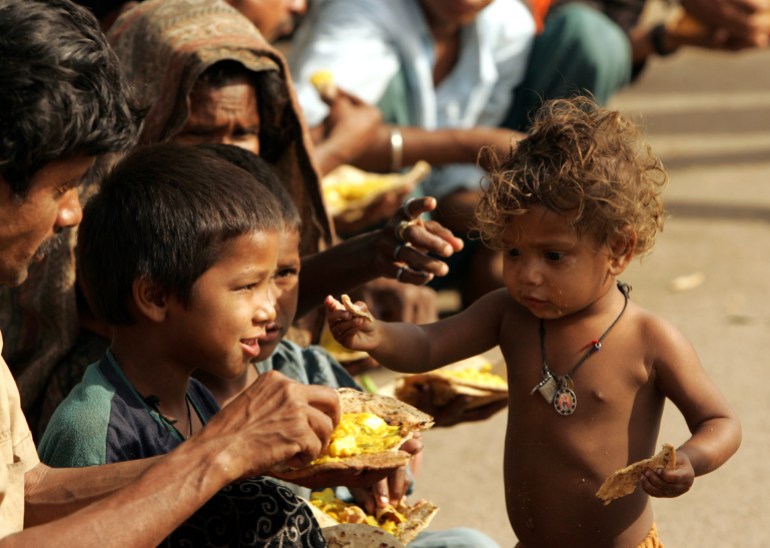 A poor family eats food at a pavement in New Delhi, April 24, 2006. Global poverty rates have fallen by as much as 10 percent over the past five years with the biggest declines in India and [China, which account for about one in three people in the world, the World Bank said.]