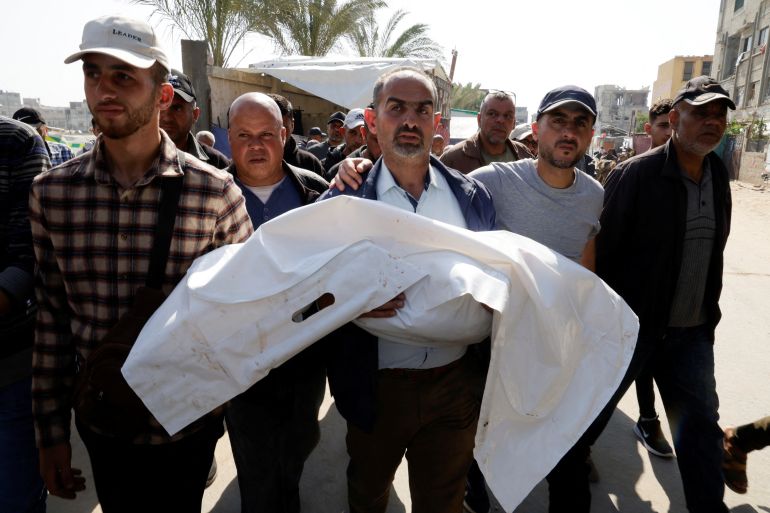 A man carries the body of a Palestinian child killed in Israeli strikes, at Nasser hospital, in Khan Younis, in the southern Gaza Strip, April 19, 2025. REUTERS/Hatem Khaled