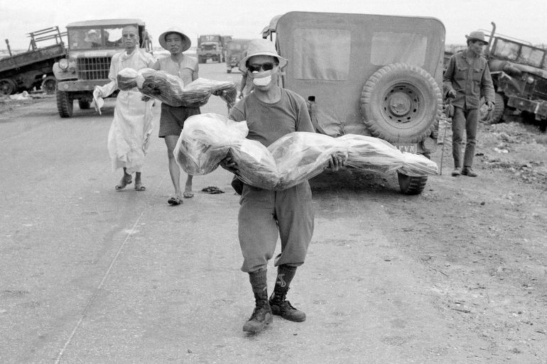Civilians carry bodies of relatives, July 11, 1972, killed in an ambush along Route 1, south of Quang Tri, Vietnam, two months ago. A Buddhist priest accompanies them here to a simple grave along roadside. (AP Photo)