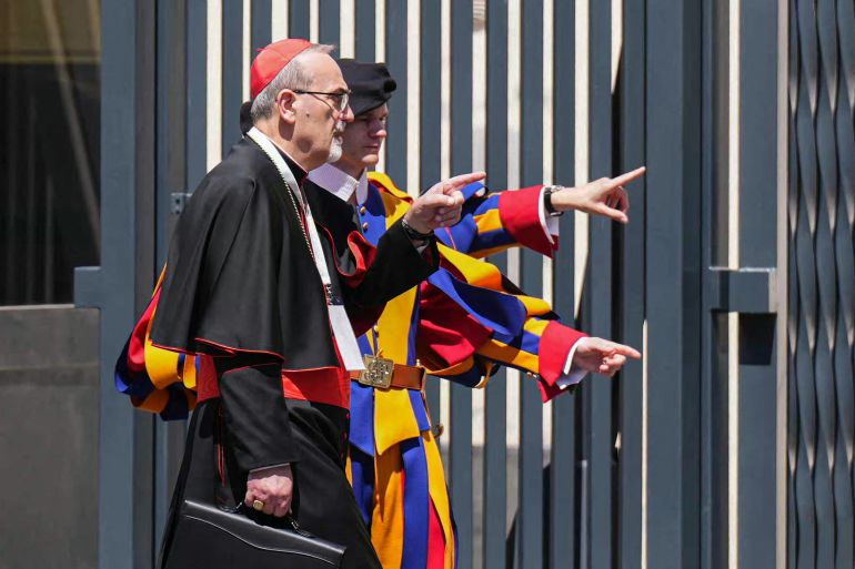Italian cardinal and Latin Patriarch of Jerusalem Pierbattista Pizzaballa (L) gestures next to Swiss guards as he leaves The Vatican, on April 30, 2025. (Photo by Dimitar DILKOFF / AFP)