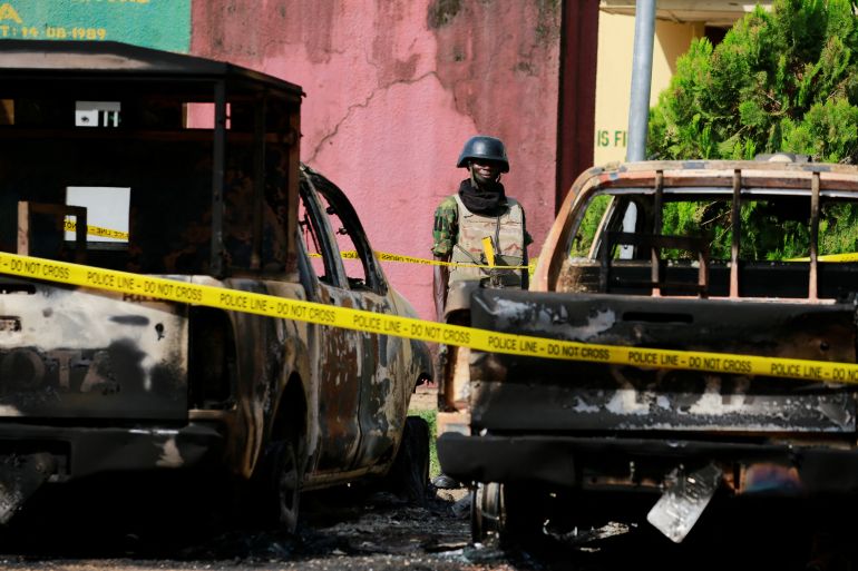 A soldier stands guard between burnt vehicles during Nigeria's President Muhammadu Buhari's visit to the Kuje prison, after gunmen released imprisoned Boko haram fighters from the prison, in Abuja, Nigeria July 6, 2022. Reuters/Afolabi Sotunde