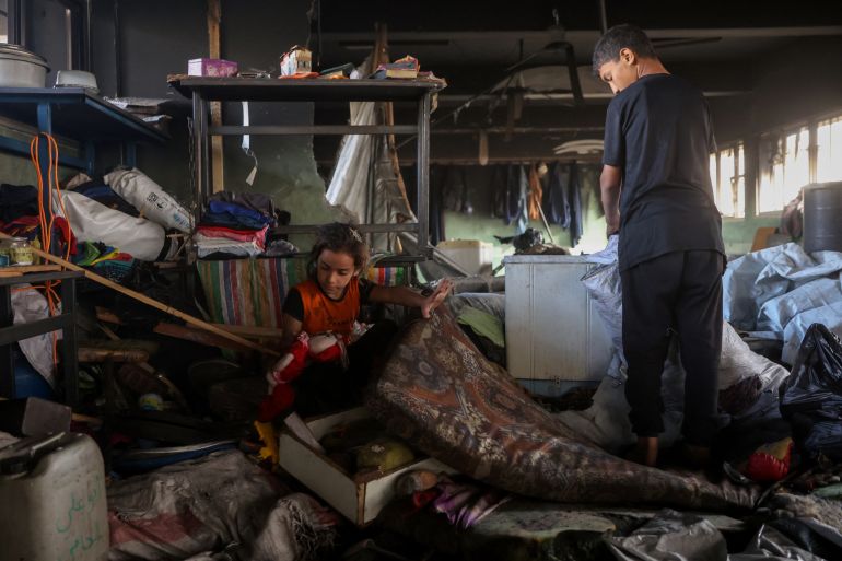 Palestinian children look for salvageable items amid the debris after an Israeli airstrike hit the Mussa bin Nusseir UNRWA school, serving as a shelter for people who left their homes in the besieged Palestinian territory, in Gaza City's Daraj district on May 20, 2025.