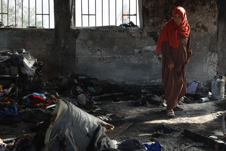 A Palestinian woman stands amid burnt items inside a classroom after an Israeli airstrike hit the Mussa bin Nusseir UNRWA school, serving as a shelter for people who left their homes in the besieged Palestinian territory, in Gaza City's Daraj district on May 20, 2025.