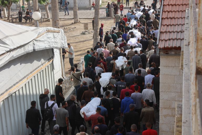 Palestinian mourners walk in the funeral procession of relatives killed in an Israeli airstrike that hit an UNRWA school, serving as a shelter for people who left their homes in the besieged Palestinian territory, on the grounds of Gaza City's Al-Ahli Arab hospital, also known as the Baptist hospital, on May 20, 2025.