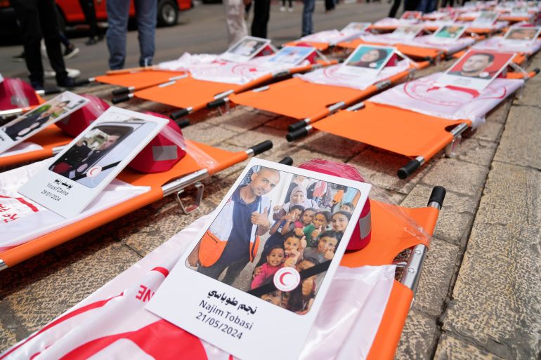 Posters with names and pictures of fallen paramedics during a symbolic funeral for 48 Palestinian Red Crescent Society members who lost their lives in the line of humanitarian duty during the Israel Hamas war in Gaza, according to a PRCS statement, marking the World Day of Red Cross and Red Crescent, in the West Bank city of Ramallah Monday, May 12, 2025. (AP Photo/Nasser Nasser)