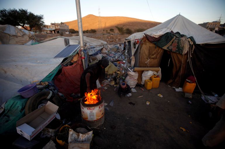 A displaced Yemeni woman ligths a fire in a makeshift camp near Sanaa, Yemen November 17, 2017. REUTERS/Mohamed al-Sayaghi